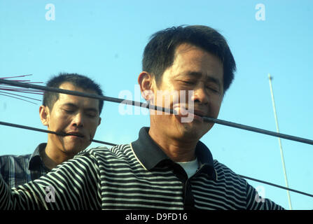 Doloroso Folk Art una speciale arte popolare attività si svolge in Ding an di Haikou, provincia di Hainan in Cina. Gli esecutori pierce loro guance con pesanti barre di ferro e li spinge fuori l'altro lato della loro bocca. Le prestazioni mozzafiato attira più di 10.000 spettatori. Una volta che gli artisti hanno finito sfregiarli essi stessi, ritirare le barre di ferro e hanno rapidamente a Foto Stock