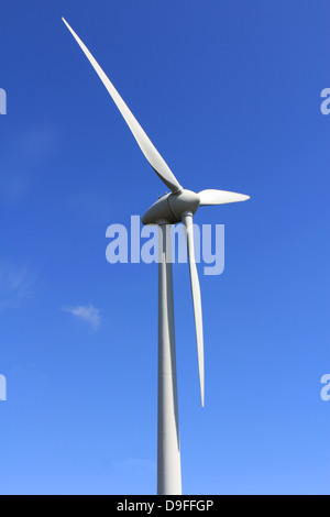 Turbina eolica contro il cielo blu, che mostra la rotazione delle pale. Foto Stock