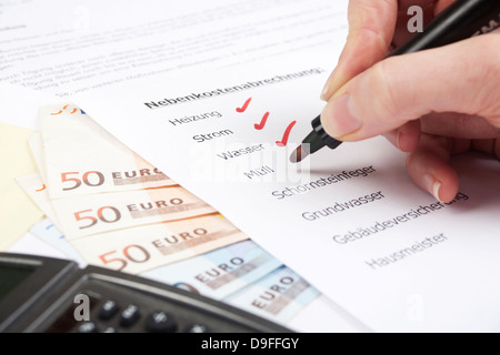 Regolamento delle spese con banconote e calcolatrice tascabile di carico con insediamento di Bill e calcolatrice Foto Stock