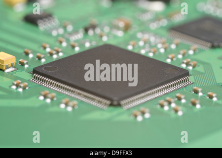Dettaglio di una scheda a circuito stampato con piste conduttrici, resistenze e un chip per computer Foto Stock