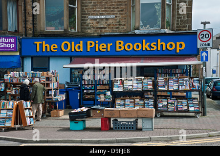 Coppia la gente più anziana che guarda i libri usati di seconda mano fuori del negozio Store Marine Road Morecambe Lancashire England GB Gran Bretagna UK Regno Unito Foto Stock