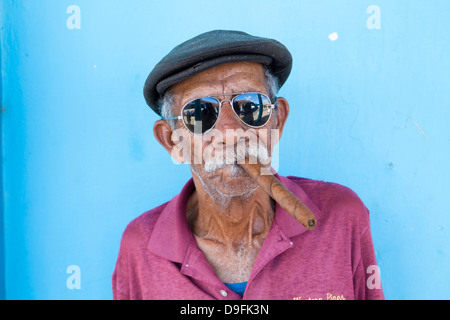 Il vecchio uomo che indossa gli occhiali da sole e il tappo piatto, fumatori big sigaro cubano, Vinales, Pinar Del Rio Provincia, Cuba, West Indies Foto Stock