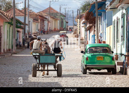 Cavallo, carrello e vintage americano auto sulla strada del centro di Trinidad, Sito Patrimonio Mondiale dell'UNESCO, Cuba, West Indies Foto Stock