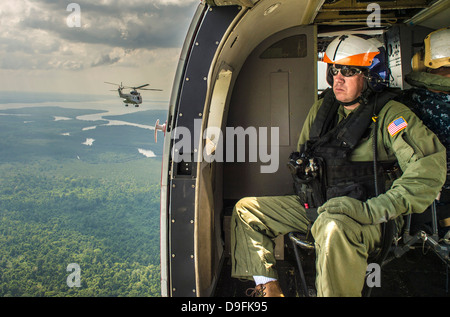 Un US Navy sailor vola sopra la giungla a bordo di una SA330J Puma elicottero attaccato al USNS Matthew Perry durante gli esercizi multilaterali Giugno 17, 2013 in Brunei. Foto Stock