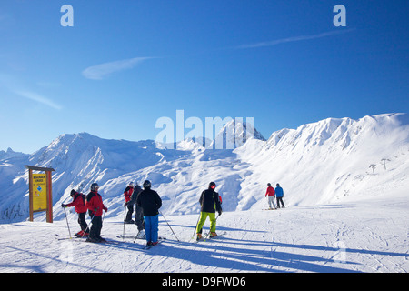 Gli sciatori sulle piste la mattina presto in inverno, La Plagne, sulle Alpi francesi, Francia Foto Stock