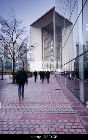 Pendolari lasciando il lavoro in La Defense area con la Grande Arche in background, Parigi, Francia Foto Stock