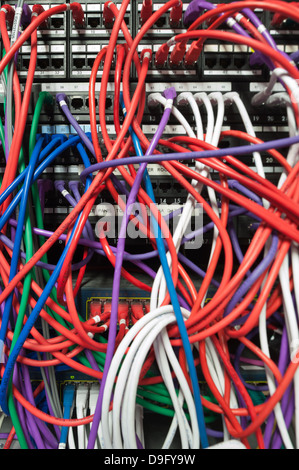 Giunzione di spaghetti all'interno di un telaio principale server dell'organizzazione di grandi dimensioni con mis match di fili aggrovigliati in cerca di confondere Foto Stock