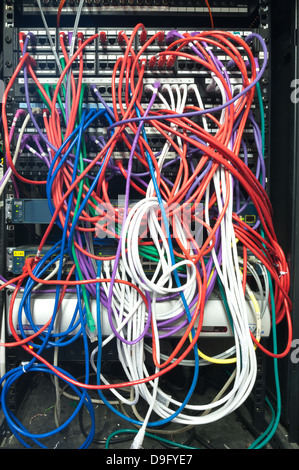 Giunzione di spaghetti all'interno di un telaio principale server dell'organizzazione di grandi dimensioni con mis match di fili aggrovigliati in cerca di confondere Foto Stock