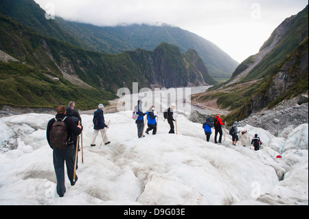 I turisti a piedi sul ghiacciaio Fox, Westland National Park, sito Patrimonio Mondiale dell'UNESCO, Isola del Sud, Nuova Zelanda Foto Stock