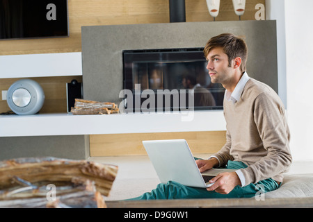 Uomo che utilizza un computer portatile a casa Foto Stock