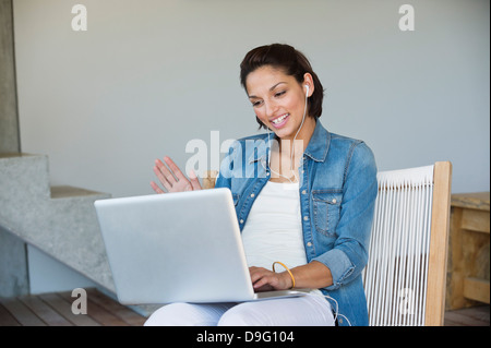 Donna fare chat online su un computer portatile Foto Stock