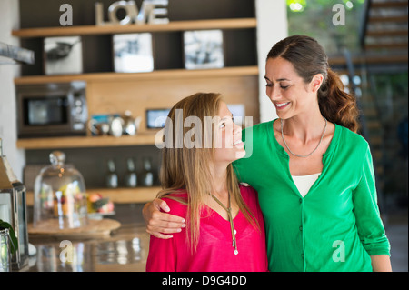 Donna sorridente con la figlia a casa Foto Stock