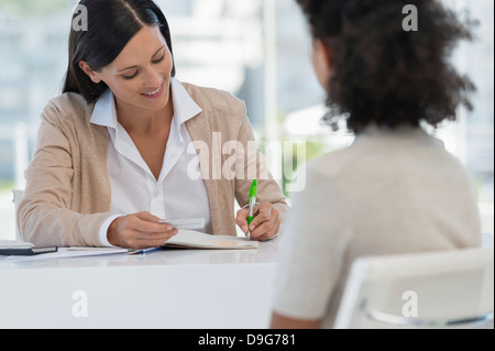 Medico donna seduta con un paziente nel suo ufficio Foto Stock