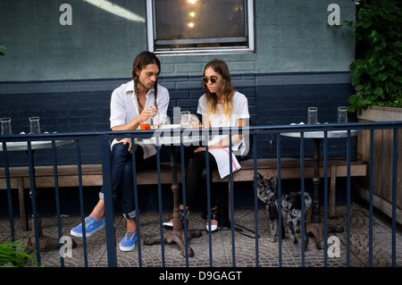 Williamsburg, Brooklyn, New York, panca, coppia giovane avente il pranzo in terrazza Foto Stock