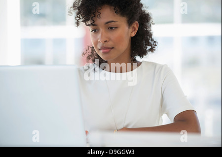 Donna al lavoro su un portatile a casa Foto Stock