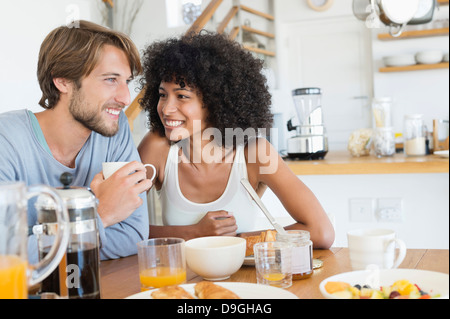 Giovane seduti ad un tavolo da pranzo con prima colazione Foto Stock