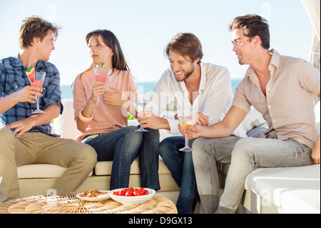 Gruppo di amici gustando un drink all'aperto in vacanza Foto Stock