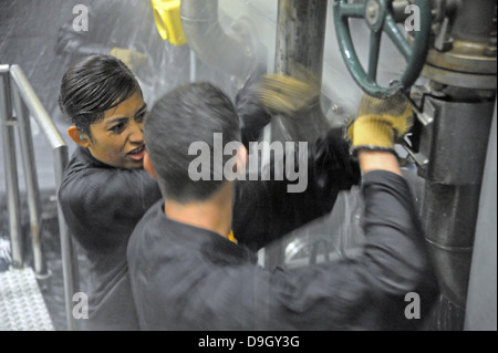 Aspiranti guardiamarina tentativo di applicare una patch a un tubo che perde. Foto Stock