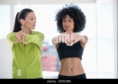 Donna che esercitano con il suo istruttore in una palestra Foto Stock