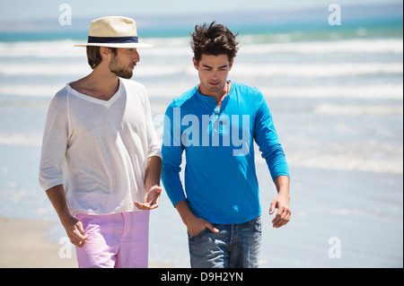 Due uomini a piedi sulla spiaggia Foto Stock