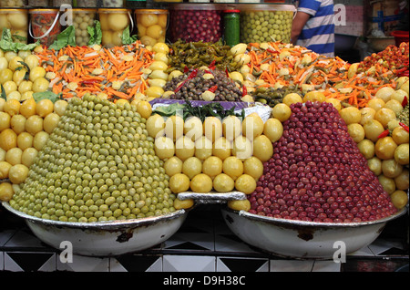 Pressione di stallo di mercato la vendita di olive fresche e prodotti alimentari in bottiglia a Marrakech, Marocco Foto Stock
