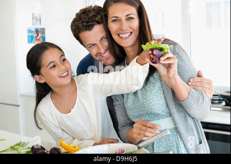 Coppia con la loro figlia godendo in cucina Foto Stock