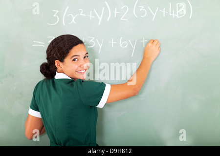 Donna sorridente studente studente iscritto matematica sulla lavagna in aula Foto Stock