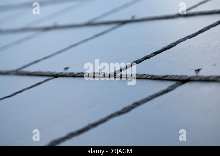 Dettagli architettonici che mostra moderna in piastrelle di ardesia tetto con ampio grigio blu piastrelle inclinata detenute da chiodi Foto Stock