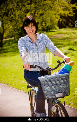 Giovane donna caucasica in bicicletta tradizionale stile shopper Foto Stock