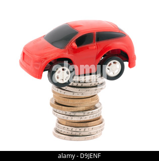 Red giocattolo auto sulla pila di monete metalliche in euro Foto Stock