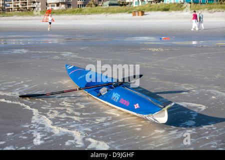 Blue Ocean kayak seduto sulla Spiaggia di Jacksonville presso la linea di surf, un bagnino sedia, pareggiatore e giovane visibile in background. Foto Stock