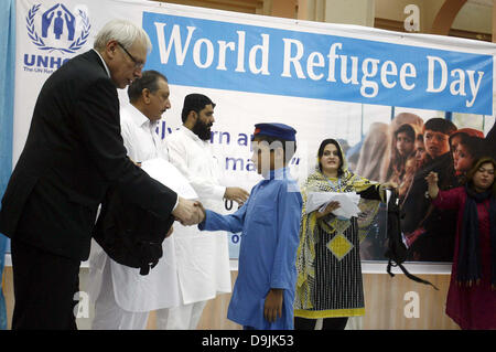 Alto Commissario delle Nazioni Unite per i rifugiati capo dell ufficio secondario a Peshawar, Jacques Franquin distribuisce premi tra i rifugiati afghani durante la cerimonia in occasione della Giornata Mondiale del Rifugiato organizzato dall'UNHCR presso Puta Hall University di Peshawar, giovedì 20 giugno, 2013. Foto Stock