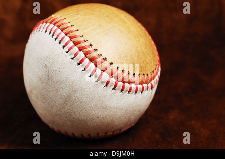 Il baseball sporchi, bianco e marrone contro uno sfondo scuro, close-up Foto Stock