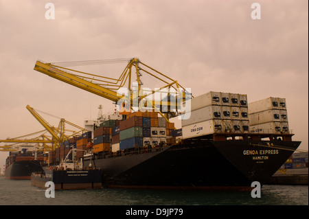 Nave container essendo caricato con contenitori mediante gru nel porto di Barcellona Foto Stock