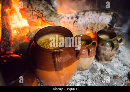 Ceci e altri impulsi in vasetti di terracotta, di cottura da un fuoco aperto. Foto Stock