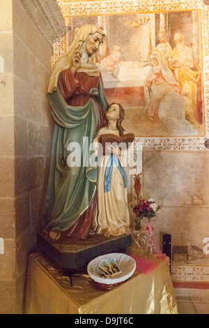 Una statua nella chiesa di Sant'Anna, Specchia Gallone, vicino Lecce, Puglia, Italia. Gli affreschi raccontano la storia su ogni parete principale. Foto Stock