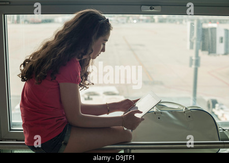 Ragazza adolescente utilizzando tavoletta digitale Foto Stock