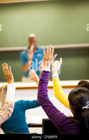 Gruppo di studenti le braccia in alto in aula Foto Stock