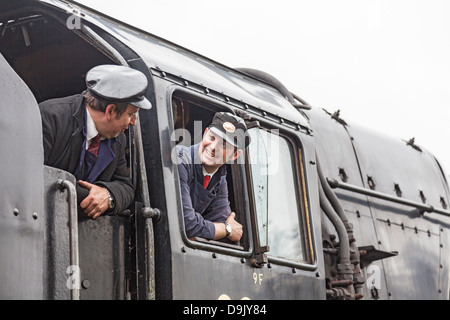 Ferrovia Bluebell, East Grinstead, West Sussex, Regno Unito - due ferrovieri chiacchierando e gustando uno scherzo Foto Stock