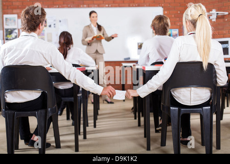 High school boy passando amore nota per una ragazza che ama in aula Foto Stock