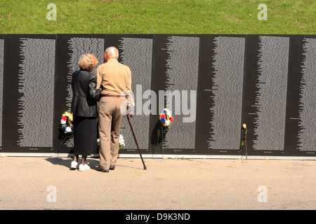 La gente giovane guardando il viaggio Vietnam War Memorial Wall uomo donna Fiori di canna Foto Stock