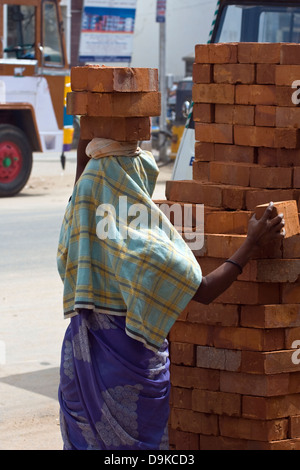 Asia, India, nello Stato del Tamil Nadu, Kanchipuram, una femmina operaio edile mattoni trasporta sulla sua testa Foto Stock