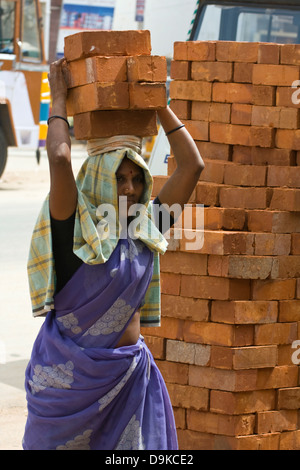 Asia, India, nello Stato del Tamil Nadu, Kanchipuram, una femmina operaio edile mattoni trasporta sulla sua testa Foto Stock