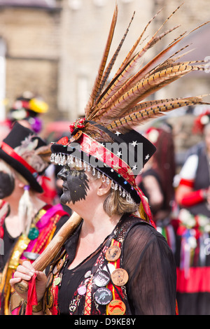 Femmina ballerino Morris con faccia nera e piume in il suo cappello a Skipton, North Yorkshire, Inghilterra Foto Stock