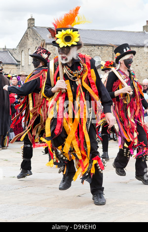 Maschio ballerino Morris con volto nero e giallo girasole a Skipton, North Yorkshire, Inghilterra Foto Stock