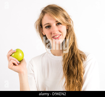 Un sano giovane donna con capelli lunghi biondi tenendo una mela verde Foto Stock