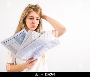 Una giovane donna con capelli lunghi biondi preoccupati per pagare la sua famiglia bollette - denaro preoccupazioni Foto Stock