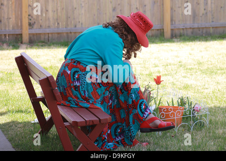 Pretty Woman tendente a fiori in un giardino Foto Stock