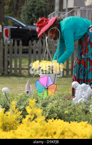 Pretty Woman tendente a fiori in un giardino Foto Stock