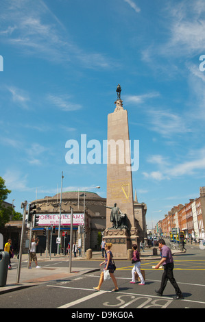 Le persone che attraversano la strada di fronte al monumento di Parnell (1911) O'Connell street superiore centrale di Dublino Irlanda Europa Foto Stock